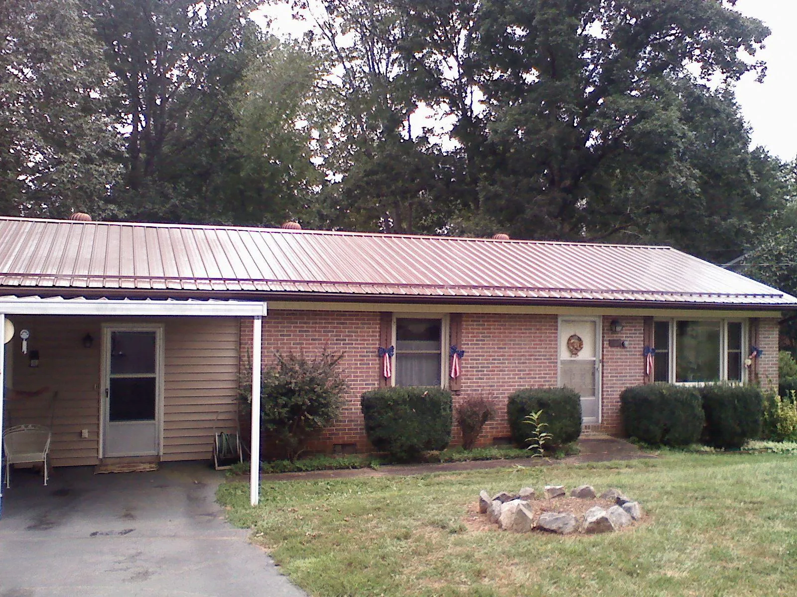 Bronze metal roof and carport on a brick ranch home — Roof Repair work by our crew in Summit